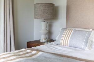 Funda de cojín de lino con rayas blancas, grises y camel en dormitorio 2